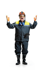 Image showing The studio shot of senior bearded male miner standing at the camera on a white background.