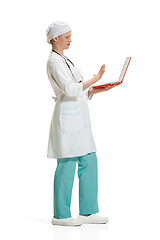 Image showing Beautiful young woman in white coat posing at studio. Full length studio shot isolated on white.