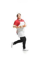 Image showing Portrait of cute smiling woman with pastries in her hands in the studio, isolated on white background