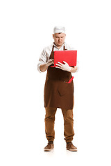 Image showing Serious butcher posing with a laptop isolated on white background