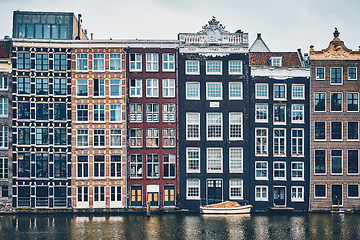 Image showing houses and boat on Amsterdam canal Damrak with reflection. Ams