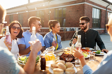 Image showing happy friends with drinks or bbq party on rooftop