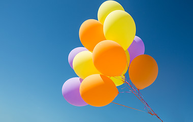 Image showing close up of colorful helium balloons in blue sky