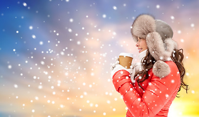 Image showing woman in winter fur hat with coffee over snow