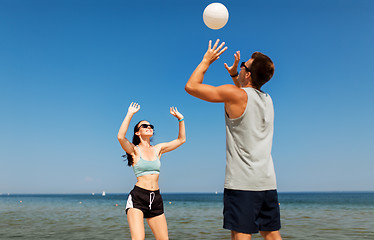 Image showing happy couple playing volleyball on summer beach