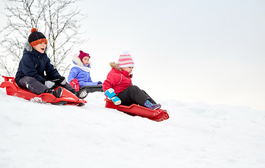 Image showing kids sliding on sleds down snow hill in winter