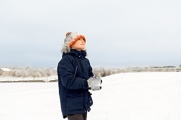 Image showing happy little boy playing with snow in winter