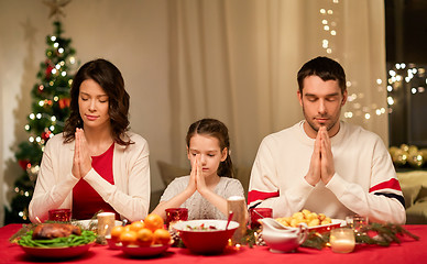 Image showing family praying before meal at christmas dinner