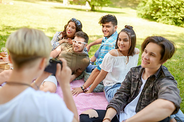 Image showing friends photographing at picnic in summer park