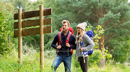 Image showing couple of travelers with backpacks at signpost