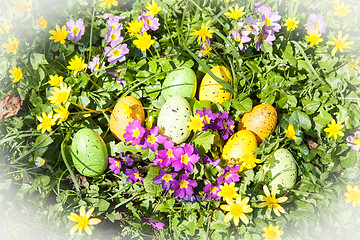 Image showing colored Easter eggs hidden in flowers and grass