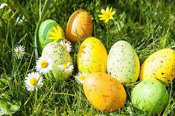 Image showing colored Easter eggs hidden in flowers and grass