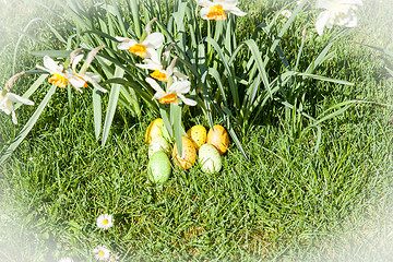 Image showing colored Easter eggs hidden in flowers and grass