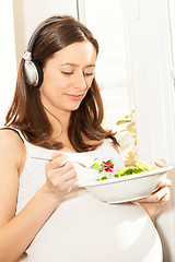 Image showing pregnant woman eat salad and listening to music