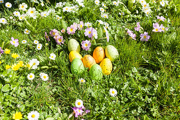 Image showing colored Easter eggs hidden in flowers and grass