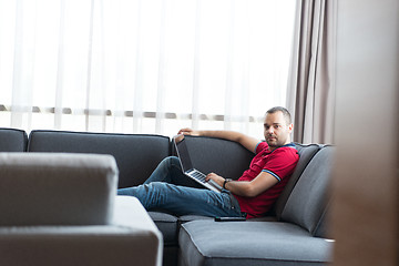 Image showing Man using laptop in living room