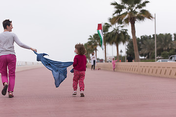 Image showing mother and cute little girl on the promenade by the sea