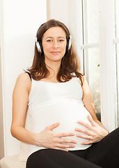 Image showing happy pregnant woman listening to music