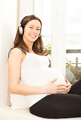 Image showing happy pregnant woman listening to music