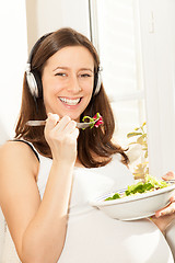 Image showing pregnant woman eat salad and listening to music