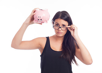 Image showing Young woman worried with a piggy bank