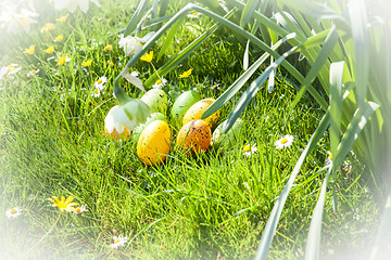 Image showing colored Easter eggs hidden in flowers and grass