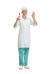 Image showing beautiful young woman doctor in medical robe holding syringe in hand.