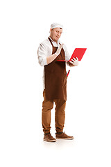 Image showing Serious butcher posing with a laptop isolated on white background