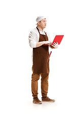 Image showing Serious butcher posing with a laptop isolated on white background