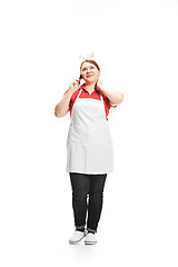 Image showing Portrait of cute smiling woman with mobile phone in her hands in the studio, isolated on white background