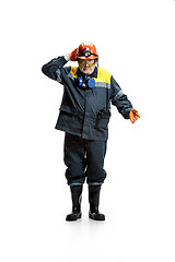 Image showing The studio shot of senior bearded male miner standing at the camera on a white background.