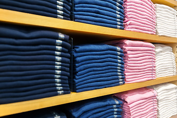 Image showing close up of shelves with clothes at clothing store