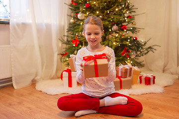 Image showing smiling girl with christmas gift at home