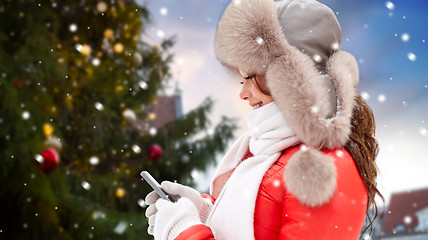 Image showing woman with smartphone over christmas tree