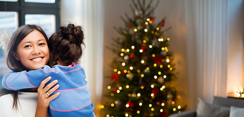 Image showing happy mother hugging her daughter on christmas