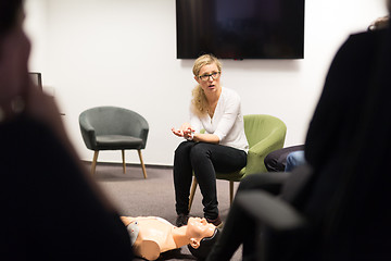 Image showing Instructor teaching first aid cardiopulmonary resuscitation course and use of automated external defibrillator on CPR workshop.