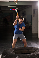 Image showing man workout with hammer and tractor tire