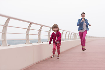 Image showing mother and cute little girl on the promenade by the sea