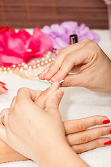 Image showing The esthetician removes the old nail polish with a cotton and remover