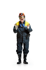 Image showing The studio shot of senior bearded male miner standing at the camera on a white background.