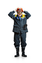 Image showing The studio shot of senior bearded male miner standing at the camera on a white background.