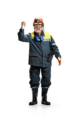 Image showing The studio shot of senior bearded male miner standing at the camera on a white background.