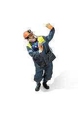 Image showing The studio shot of senior bearded male miner standing at the camera on a white background.