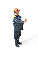 Image showing The studio shot of senior bearded male miner standing at the camera on a white background.