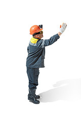 Image showing The studio shot of senior bearded male miner standing at the camera on a white background.