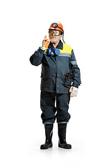 Image showing The studio shot of senior bearded male miner standing at the camera on a white background.