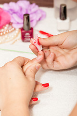 Image showing The esthetician removes the old nail polish with a cotton and remover