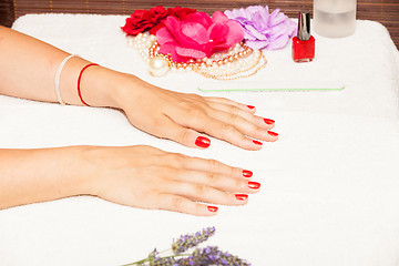 Image showing Hands of a woman with red nail polish posed by an esthetician