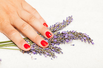 Image showing Hands of a woman with red nail polish posed by an esthetician