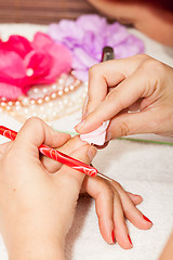 Image showing The esthetician removes the old nail polish with a cotton and remover